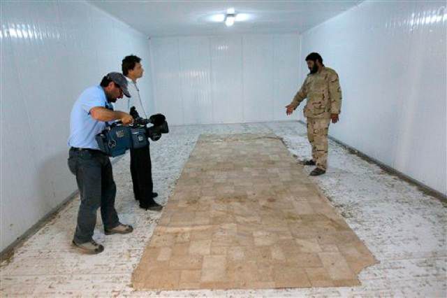 Libyan revolutionary fighter shows reporters the empty freezer in a commercial center where the body of Libyan dictator Moammar Gadhafi was displayed